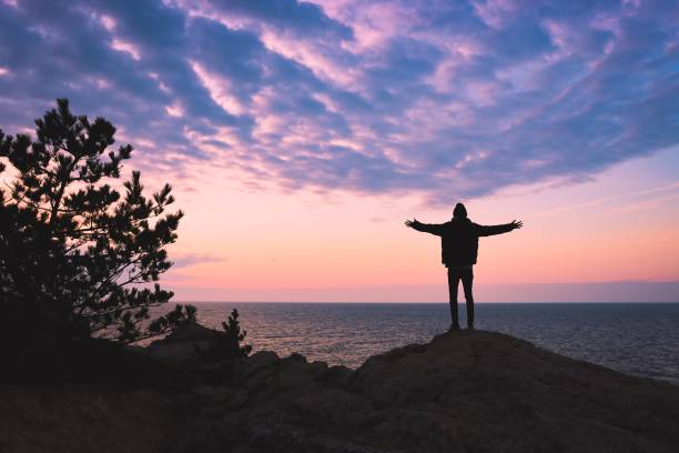 Young man praying for divine presence on a mountain.